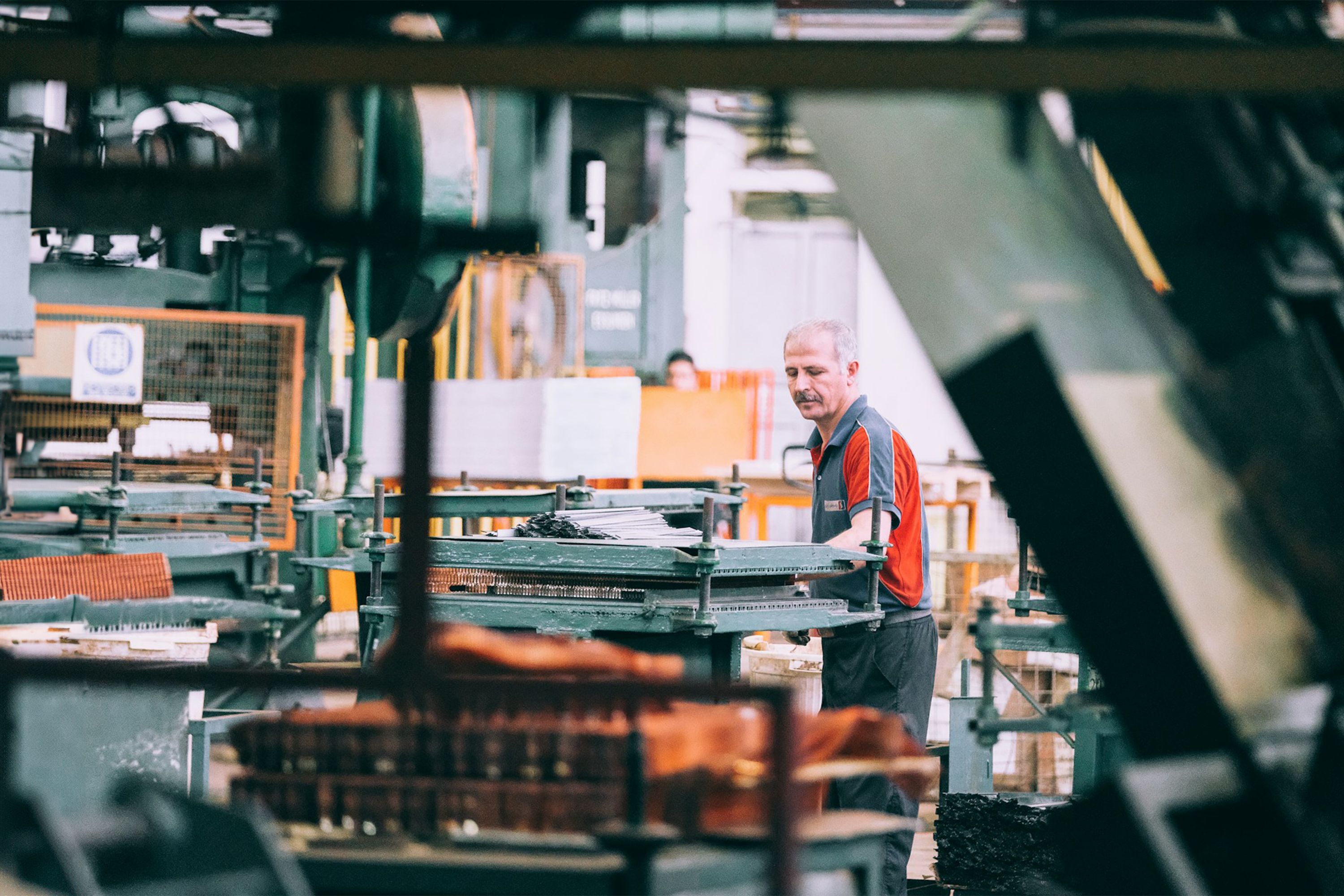 A factory worker overseeing machinery in an industrial setting.