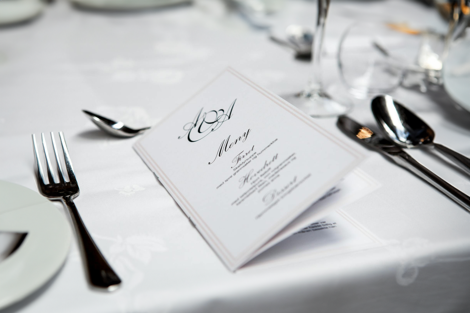 Elegant table setting with a folded menu card, silverware, and wine glasses, highlighting Trustline Enterprises' specialized printing and packaging solutions for the hospitality industry.