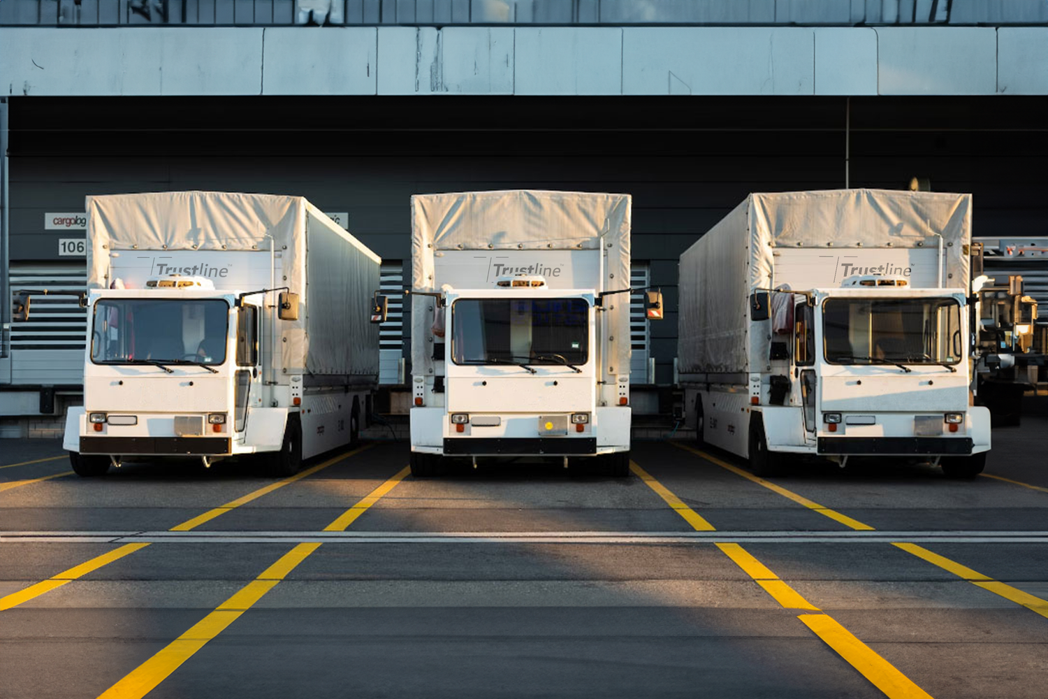 Three Trustline delivery trucks parked in a row.